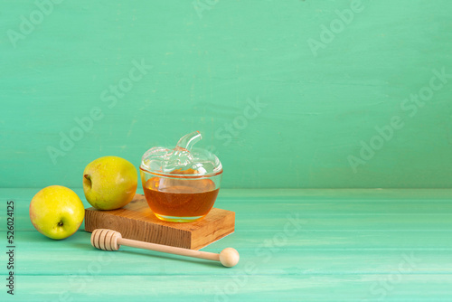 Fresh honey and apples for Jewish holiday Rosh Hashanah on green wooden background with copy space.