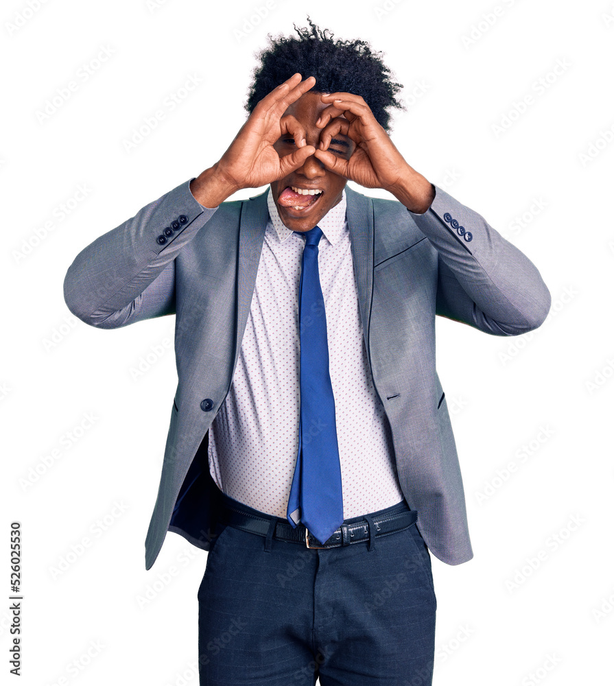 Handsome african american man with afro hair wearing business jacket doing ok gesture like binoculars sticking tongue out, eyes looking through fingers. crazy expression. Handsome african american man with afro hair wearing business jacket doing ok gesture like binoculars sticking tongue out, eyes looking through fingers. crazy expression.