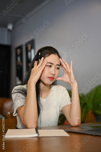 Portrait, Stressed and serious young Asian female suffering from headache