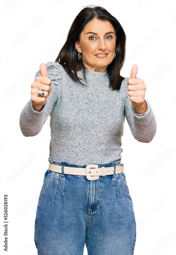 Middle age brunette woman wearing casual clothes approving doing positive gesture with hand, thumbs up smiling and happy for success. winner gesture. Middle age brunette woman wearing casual clothes approving doing positive gesture with hand, thumbs up smiling and happy for success. winner gesture.