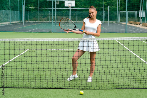 girl in a white sports dress on the tennis court. tennis court and racket.