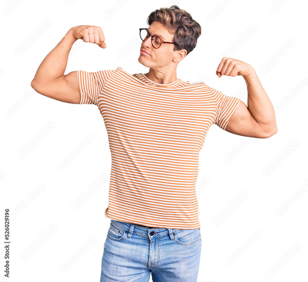 Young handsome man wearing casual clothes and glasses showing arms muscles smiling proud. fitness concept. Young handsome man wearing casual clothes and glasses showing arms muscles smiling proud. fitness concept.