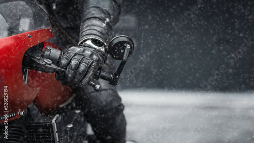 Hand in glove on motorcycle handlebar in winter, free space for insertion