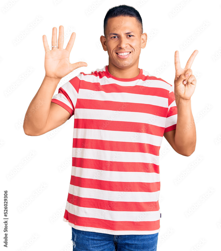 Young handsome latin man wearing casual clothes showing and pointing up with fingers number seven while smiling confident and happy. Young handsome latin man wearing casual clothes showing and pointing up with fingers number seven while smiling confident and happy.