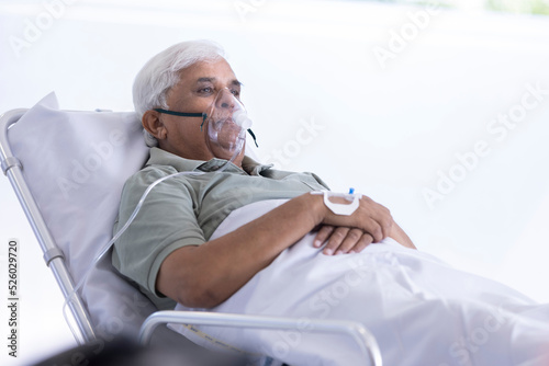 Photography Hospitalized senior patient lying on bed with oxygen mask at hospital