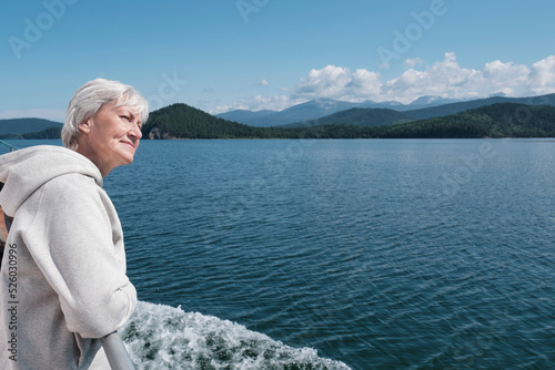 Senior caucasian woman with gray hair on boat trip. Lake Baikal, Russia.