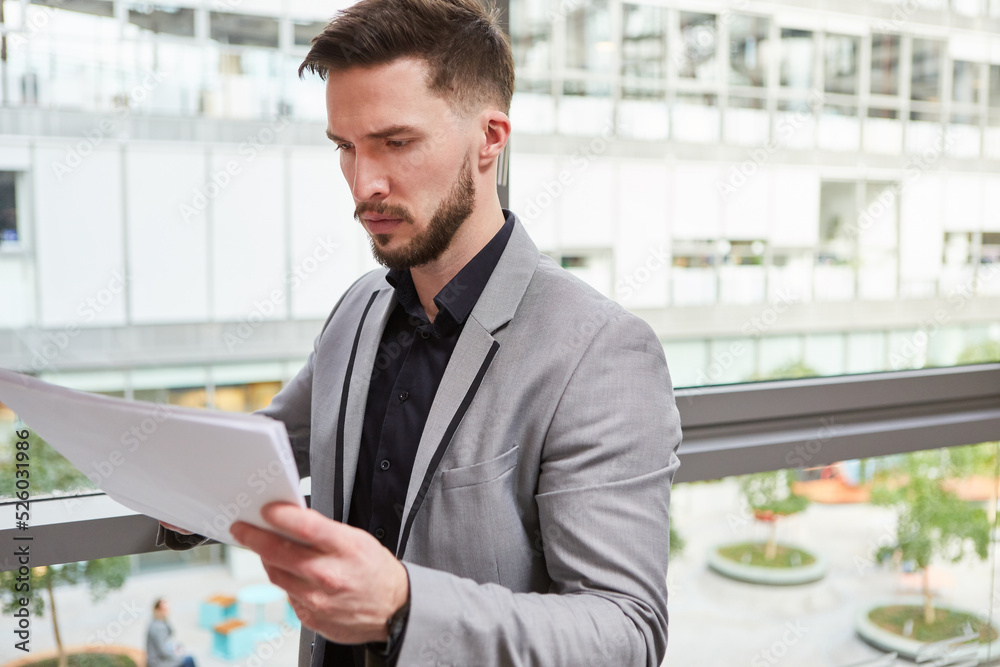Fototapeta premium Young business man controls and examines papers