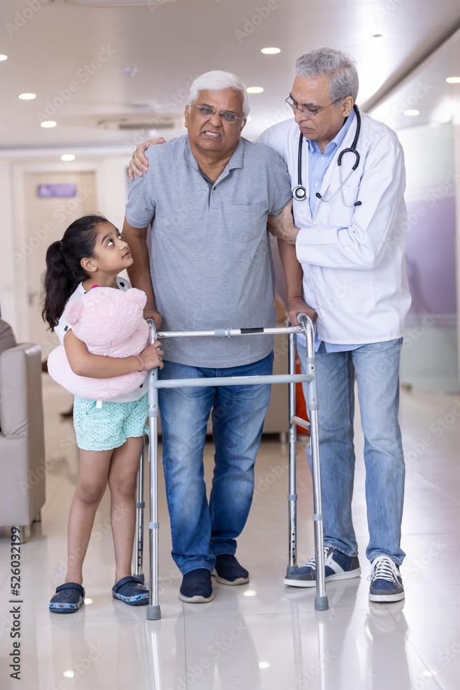 Granddaughter with male doctor teaching disabled grandfather to use walker at hospital
Granddaughter with male doctor teaching disabled grandfather to use walker at hospital
