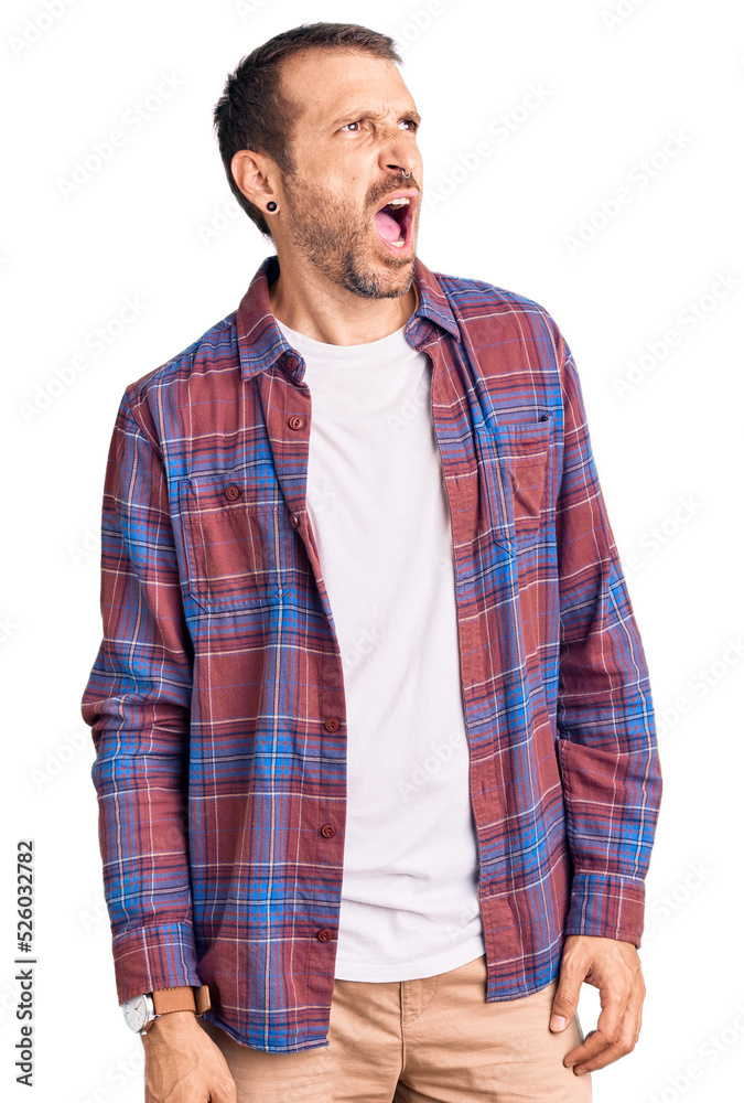 Young handsome man wearing casual clothes angry and mad screaming frustrated and furious, shouting with anger. rage and aggressive concept. Young handsome man wearing casual clothes angry and mad screaming frustrated and furious, shouting with anger. rage and aggressive concept.