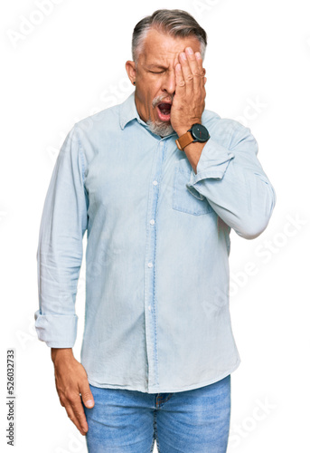 Middle age grey-haired man wearing casual clothes yawning tired covering half face, eye and mouth with hand. face hurts in pain. © Krakenimages.com
