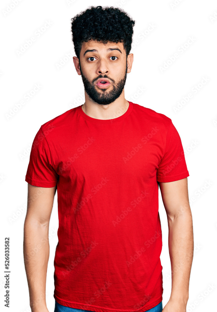 Young arab man with beard wearing casual red t shirt afraid and shocked with surprise expression, fear and excited face. Young arab man with beard wearing casual red t shirt afraid and shocked with surprise expression, fear and excited face.