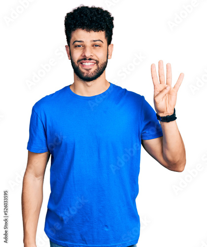 Young arab man with beard wearing casual blue t shirt showing and pointing up with fingers number four while smiling confident and happy.