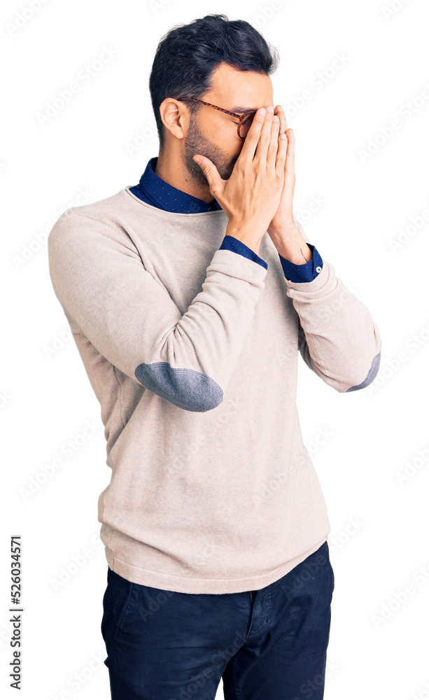 Young handsome hispanic man wearing elegant clothes and glasses with sad expression covering face with hands while crying. depression concept. Young handsome hispanic man wearing elegant clothes and glasses with sad expression covering face with hands while crying. depression concept.