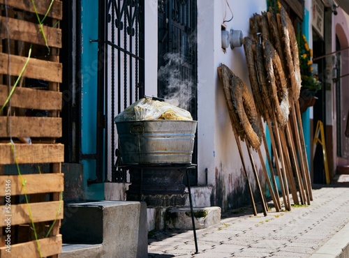 Photography View of a street in San Cristobal with wreaths leaned on the wall