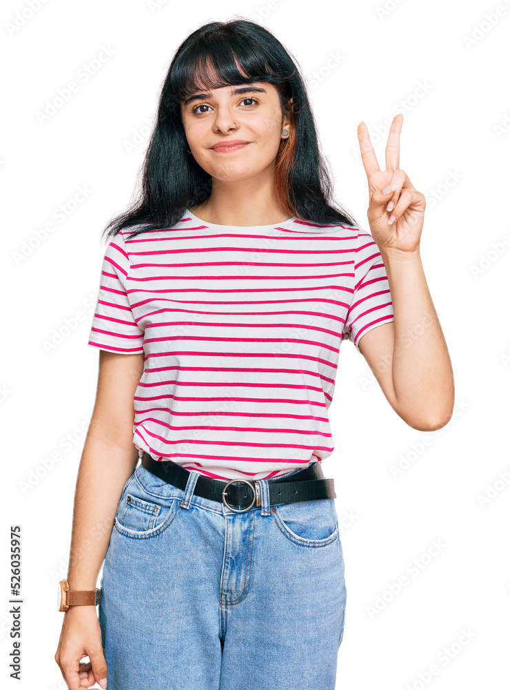 Young hispanic girl wearing casual clothes showing and pointing up with fingers number two while smiling confident and happy. Young hispanic girl wearing casual clothes showing and pointing up with fingers number two while smiling confident and happy.