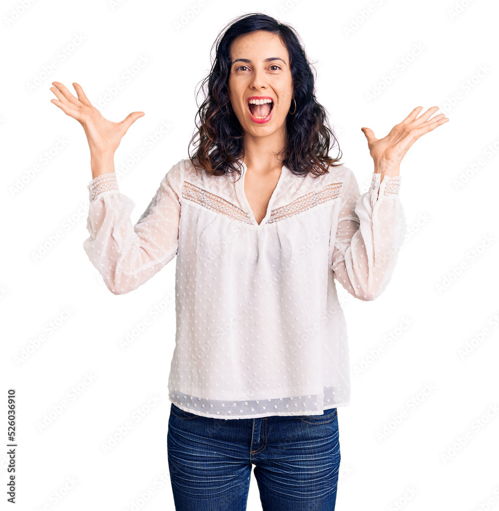 Young beautiful hispanic woman wearing casual clothes celebrating victory with happy smile and winner expression with raised hands Young beautiful hispanic woman wearing casual clothes celebrating victory with happy smile and winner expression with raised hands
