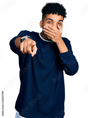 Young african american man wearing casual clothes laughing at you, pointing finger to the camera with hand over mouth, shame expression