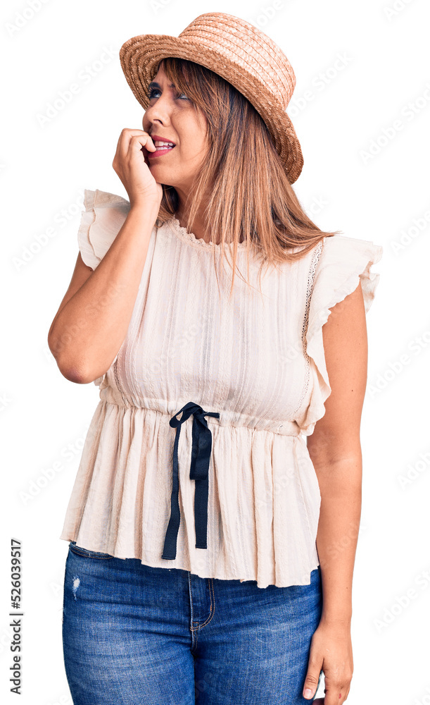 Young beautiful woman wearing summer hat and t-shirt looking stressed and nervous with hands on mouth biting nails. anxiety problem. Young beautiful woman wearing summer hat and t-shirt looking stressed and nervous with hands on mouth biting nails. anxiety problem.