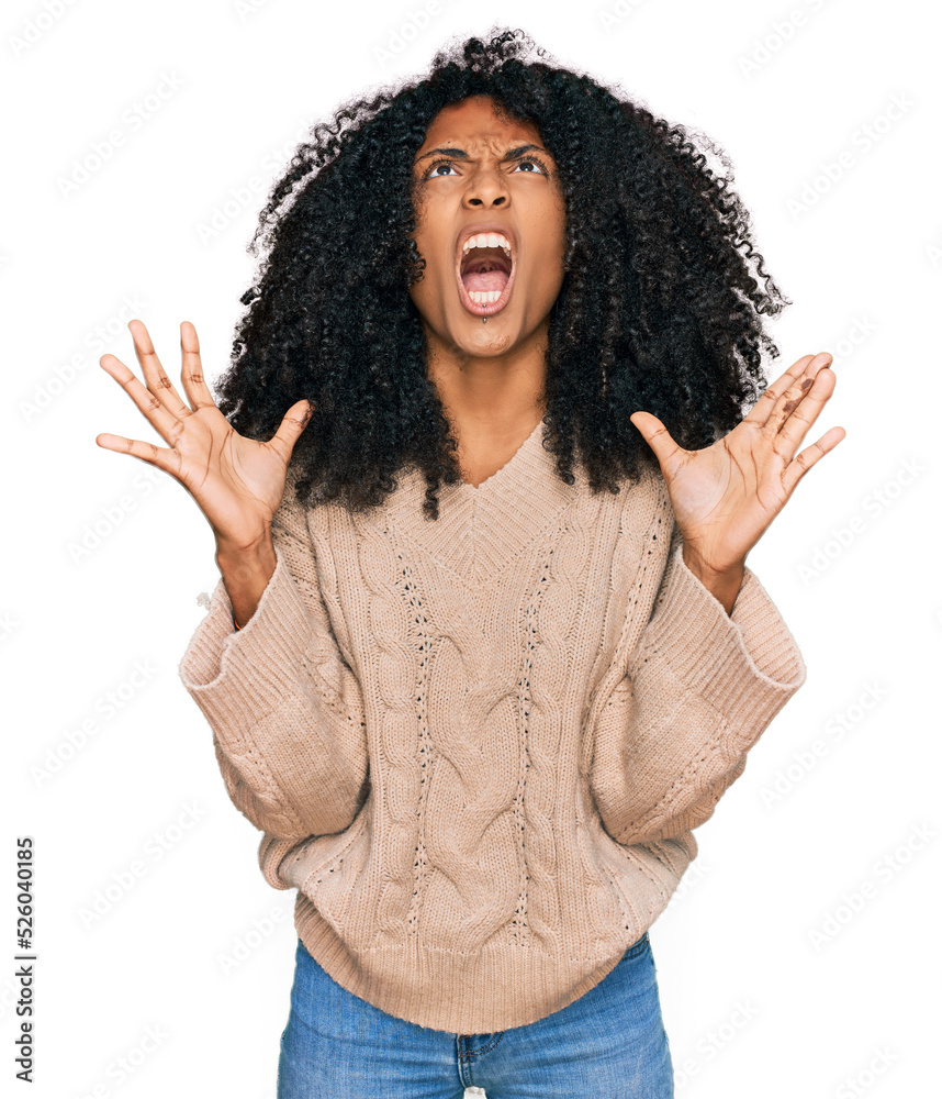 Young african american girl wearing casual clothes crazy and mad shouting and yelling with aggressive expression and arms raised. frustration concept. Young african american girl wearing casual clothes crazy and mad shouting and yelling with aggressive expression and arms raised. frustration concept.
