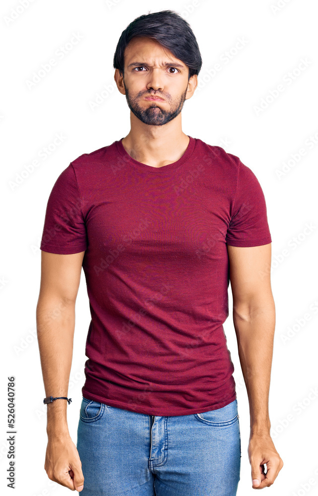 Fototapeta premium Handsome hispanic man wearing casual clothes puffing cheeks with funny face. mouth inflated with air, crazy expression.