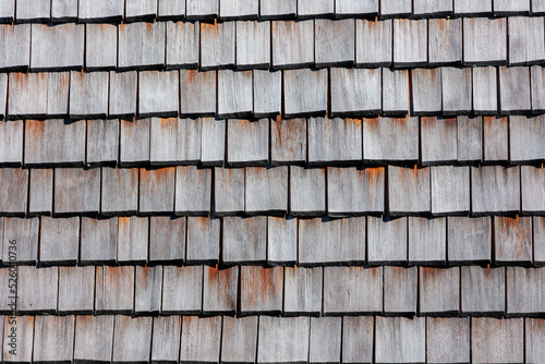 Traditional house wall cladding from weathered cut rectangular wooden shingles