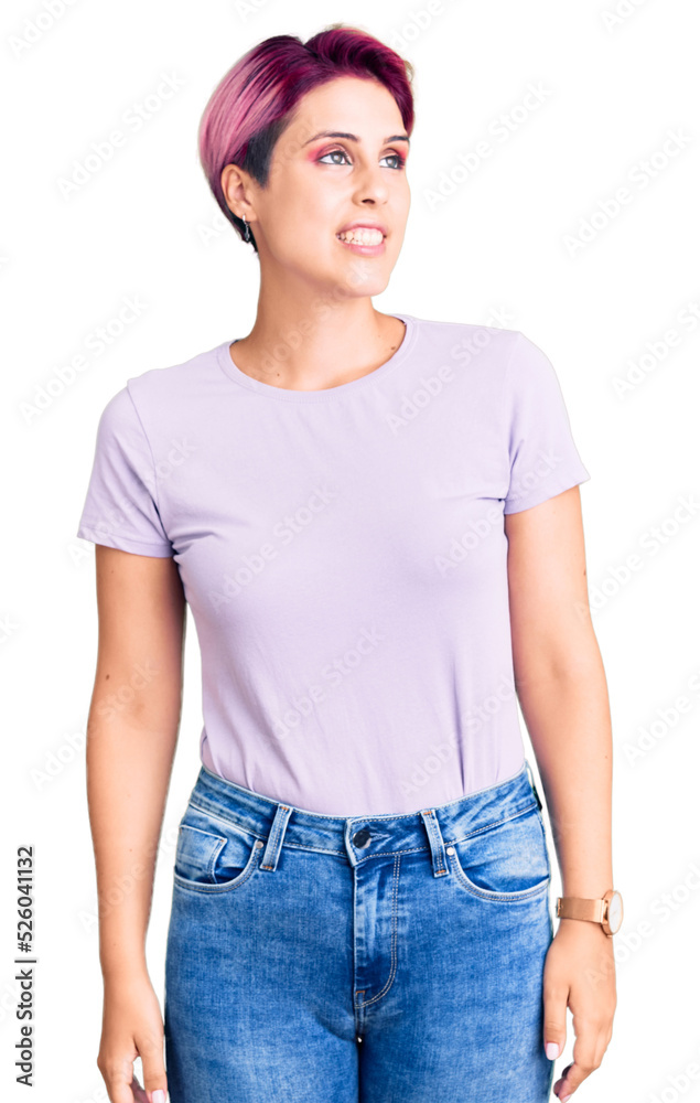 Obraz premium Young beautiful woman with pink hair wearing casual clothes looking away to side with smile on face, natural expression. laughing confident.