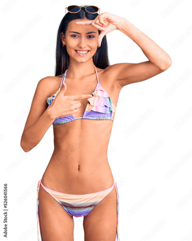 Young beautiful latin girl wearing bikini and sunglasses smiling making frame with hands and fingers with happy face. creativity and photography concept.