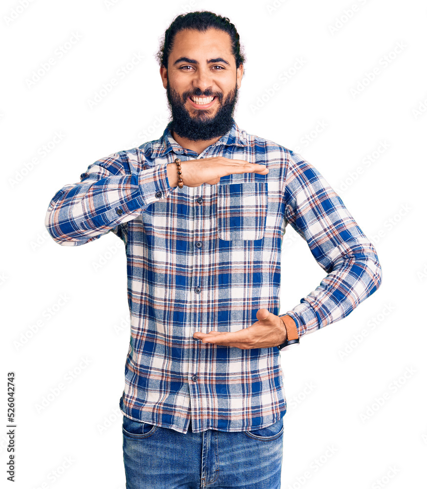 Young arab man wearing casual clothes gesturing with hands showing big and large size sign, measure symbol. smiling looking at the camera. measuring concept. Young arab man wearing casual clothes gesturing with hands showing big and large size sign, measure symbol. smiling looking at the camera. measuring concept.