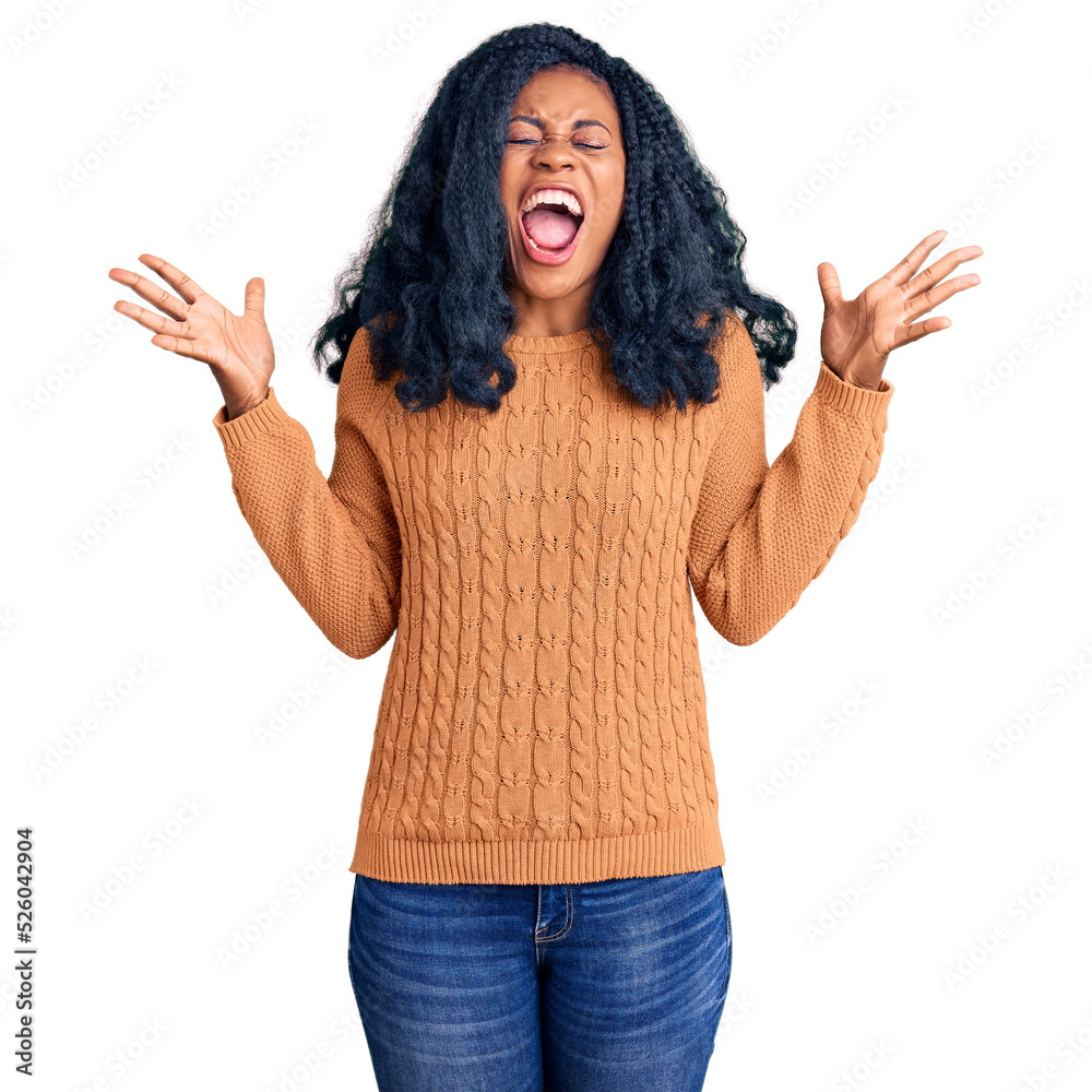 Beautiful african american woman wearing casual sweater celebrating mad and crazy for success with arms raised and closed eyes screaming excited. winner concept Beautiful african american woman wearing casual sweater celebrating mad and crazy for success with arms raised and closed eyes screaming excited. winner concept