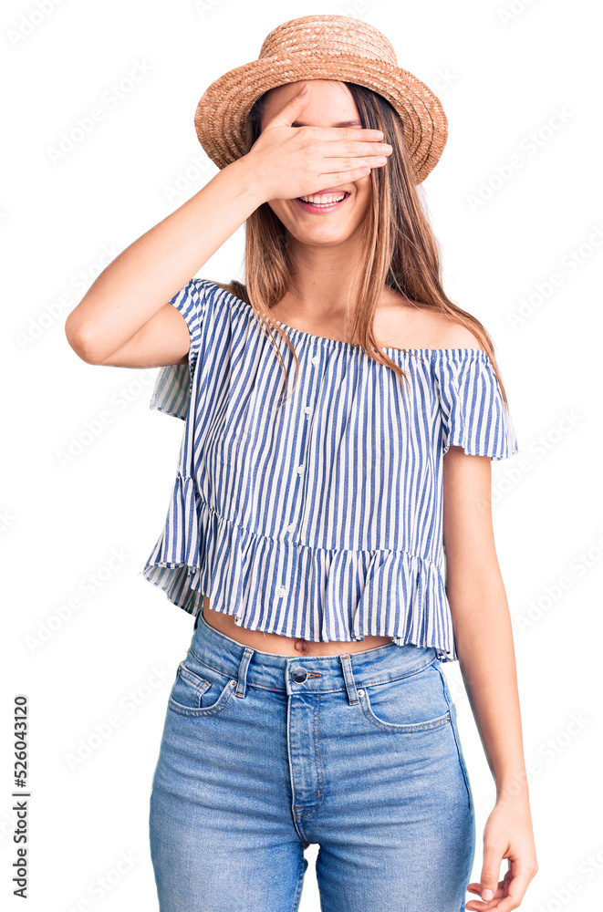 Young beautiful girl wearing hat and t shirt smiling and laughing with hand on face covering eyes for surprise. blind concept. Young beautiful girl wearing hat and t shirt smiling and laughing with hand on face covering eyes for surprise. blind concept.