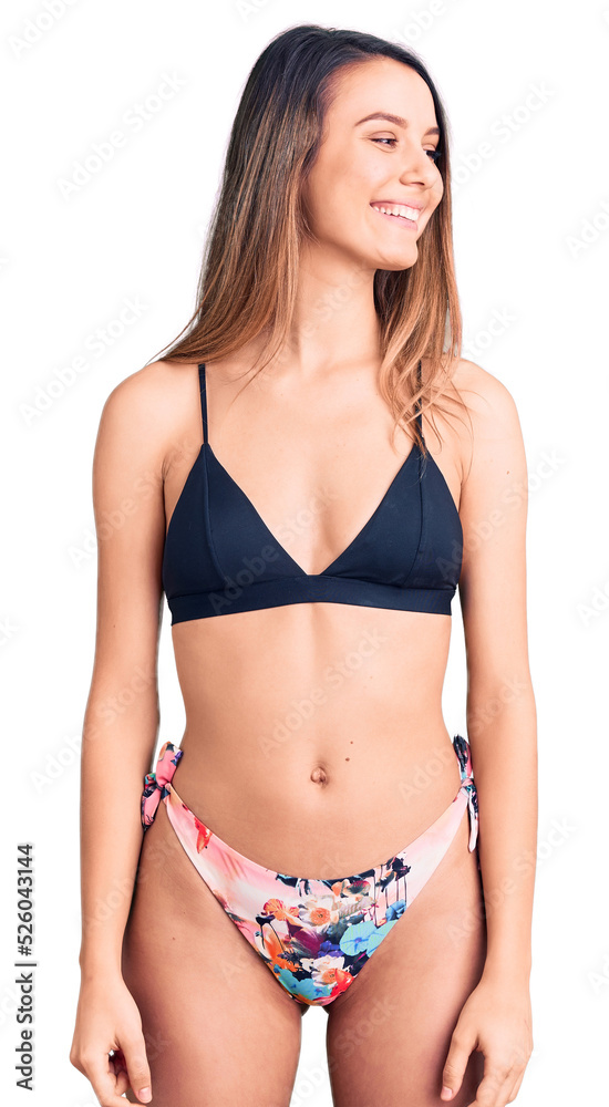 Young beautiful girl wearing bikini looking away to side with smile on face, natural expression. laughing confident. Young beautiful girl wearing bikini looking away to side with smile on face, natural expression. laughing confident.