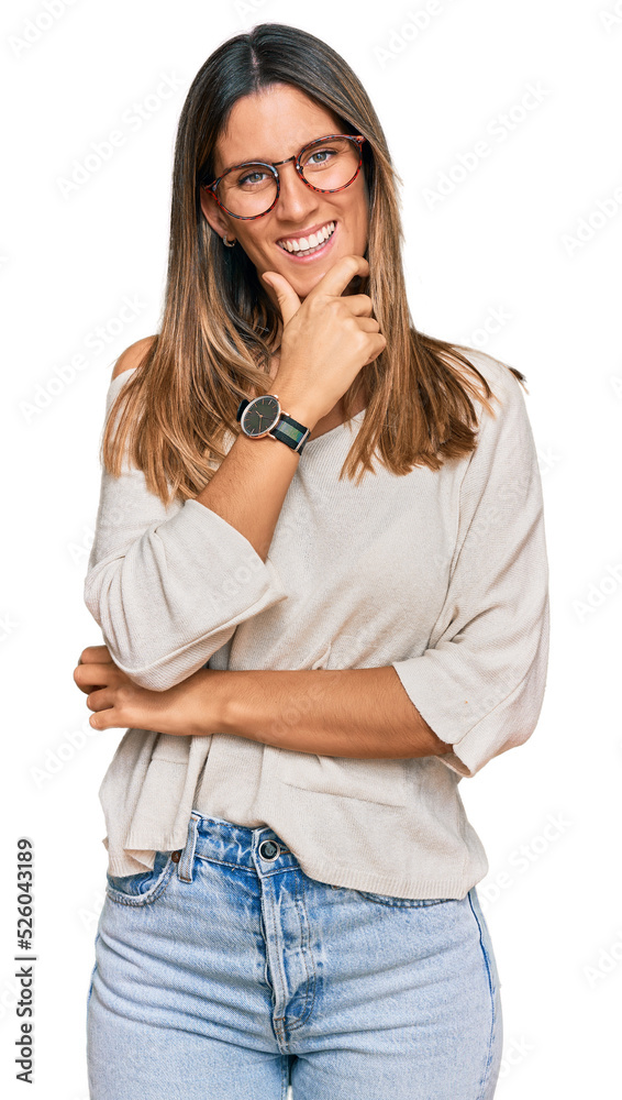 Young woman wearing casual clothes and glasses looking confident at the camera smiling with crossed arms and hand raised on chin. thinking positive. Young woman wearing casual clothes and glasses looking confident at the camera smiling with crossed arms and hand raised on chin. thinking positive.