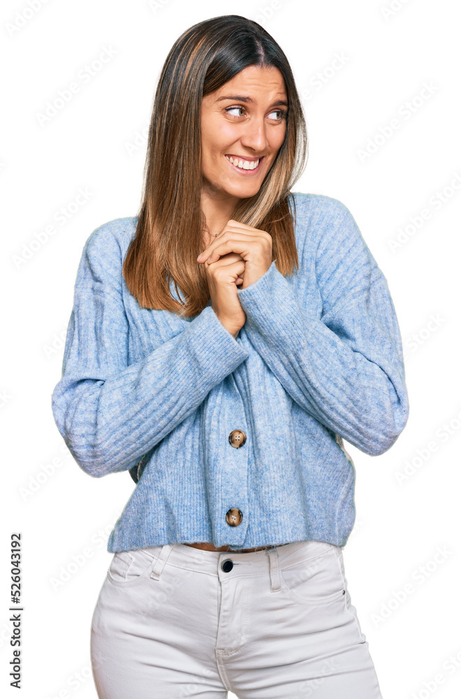 Young woman wearing casual clothes laughing nervous and excited with hands on chin looking to the side Young woman wearing casual clothes laughing nervous and excited with hands on chin looking to the side