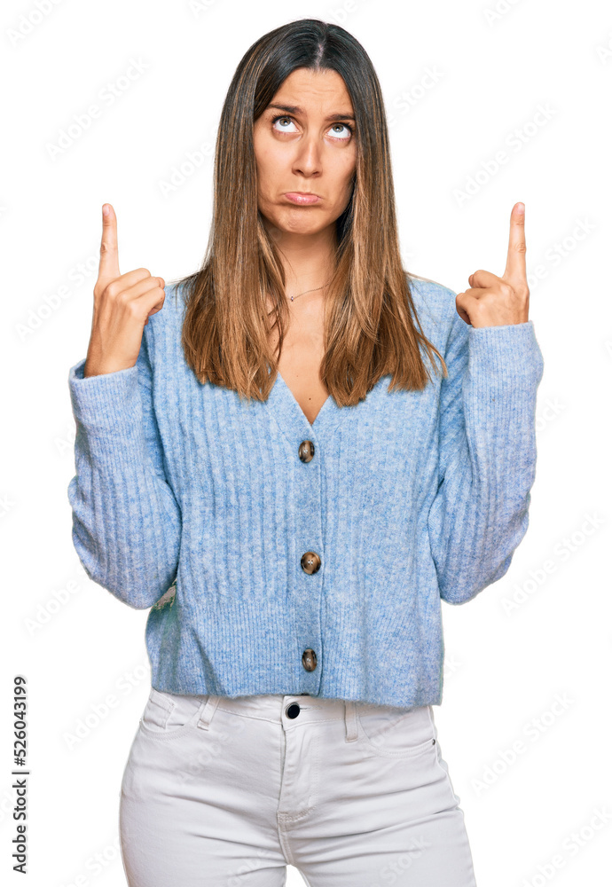 Young woman wearing casual clothes pointing up looking sad and upset, indicating direction with fingers, unhappy and depressed. Young woman wearing casual clothes pointing up looking sad and upset, indicating direction with fingers, unhappy and depressed.