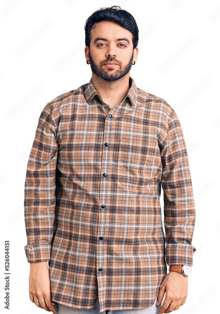 Young hispanic man wearing casual clothes relaxed with serious expression on face. simple and natural looking at the camera. Young hispanic man wearing casual clothes relaxed with serious expression on face. simple and natural looking at the camera.