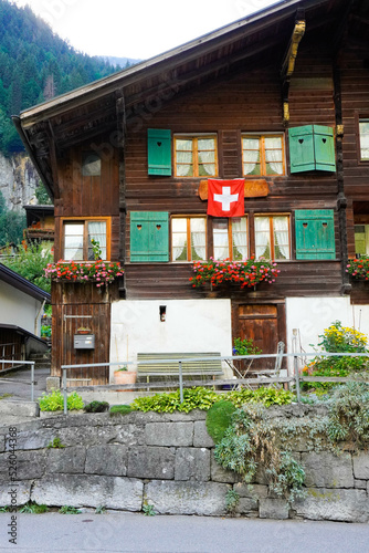 Frontal típica casa de madera con bandera de Suiza