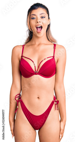 Young beautiful woman wearing bikini afraid and shocked with surprise and amazed expression, fear and excited face.