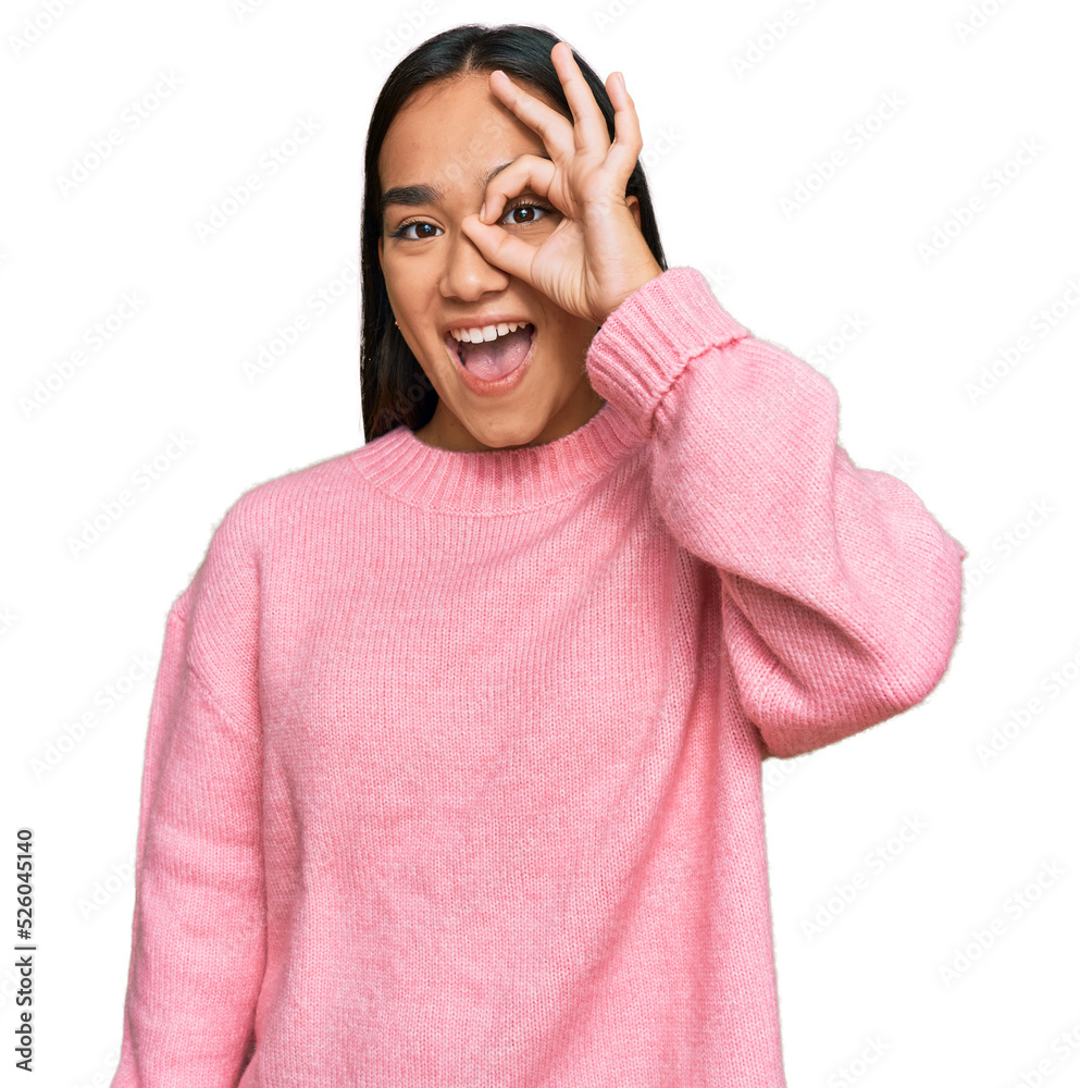 Young asian woman wearing casual winter sweater doing ok gesture with hand smiling, eye looking through fingers with happy face. Young asian woman wearing casual winter sweater doing ok gesture with hand smiling, eye looking through fingers with happy face.