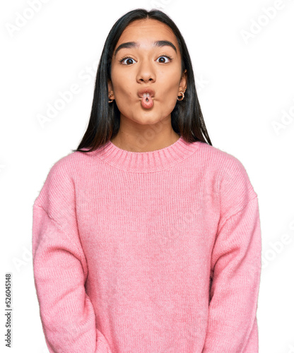 Young asian woman wearing casual winter sweater making fish face with lips, crazy and comical gesture. funny expression.