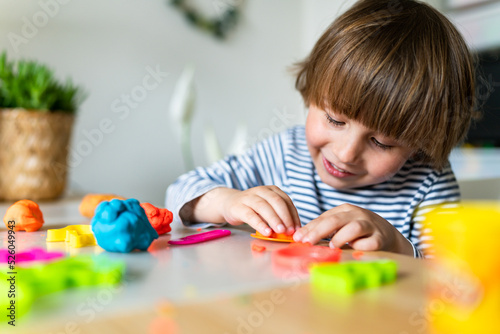 Toddler child playing with modeling compound set at home. Kid  early development, creative play