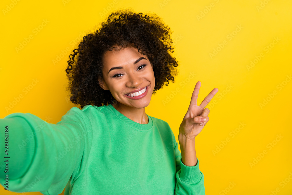 Portrait of funny pretty person take selfie hand fingers demonstrate v-sign isolated on yellow color background Portrait of funny pretty person take selfie hand fingers demonstrate v-sign isolated on yellow color background