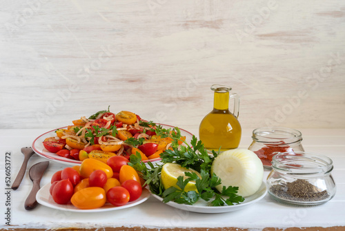 Ingredients for Summer Cherry Tomato Salad on white wooden background with copy space.