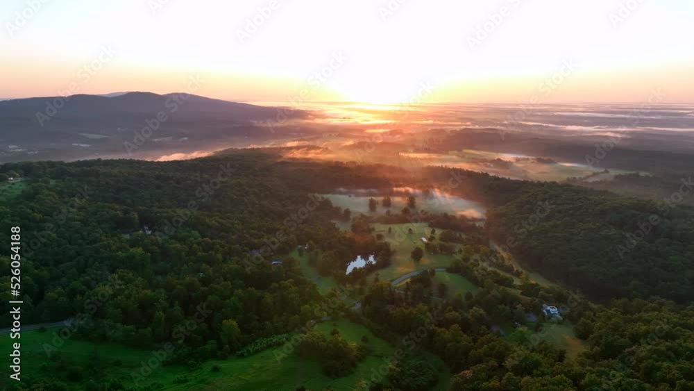 Beautiful mountain views at sunrise. Fog in valley as colorful sun rises on horizon. Aerial view. Beautiful mountain views at sunrise. Fog in valley as colorful sun rises on horizon. Aerial view.