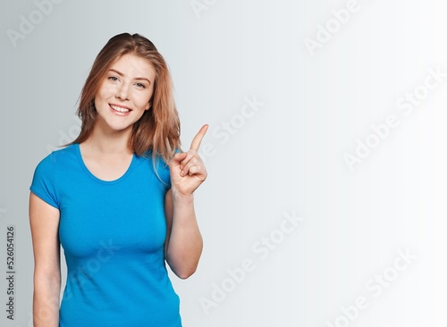 Happy student girl finger pointing on background.