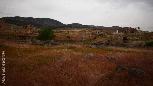 Panning from grey skies to burned brown grass at ancient roman Hierapolis site in Denzil Turkey photo