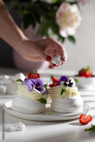 Decorating pavlova's dessert with flowers and berries © Татьяна Медведцкая