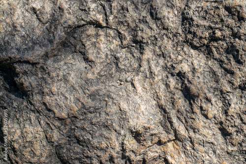 Raw granite rock texture background. Fragment of natural stone wall.