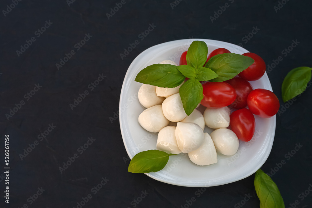 Mini mozzarella with tomatoes and basil on a plate Mini mozzarella with tomatoes and basil on a plate