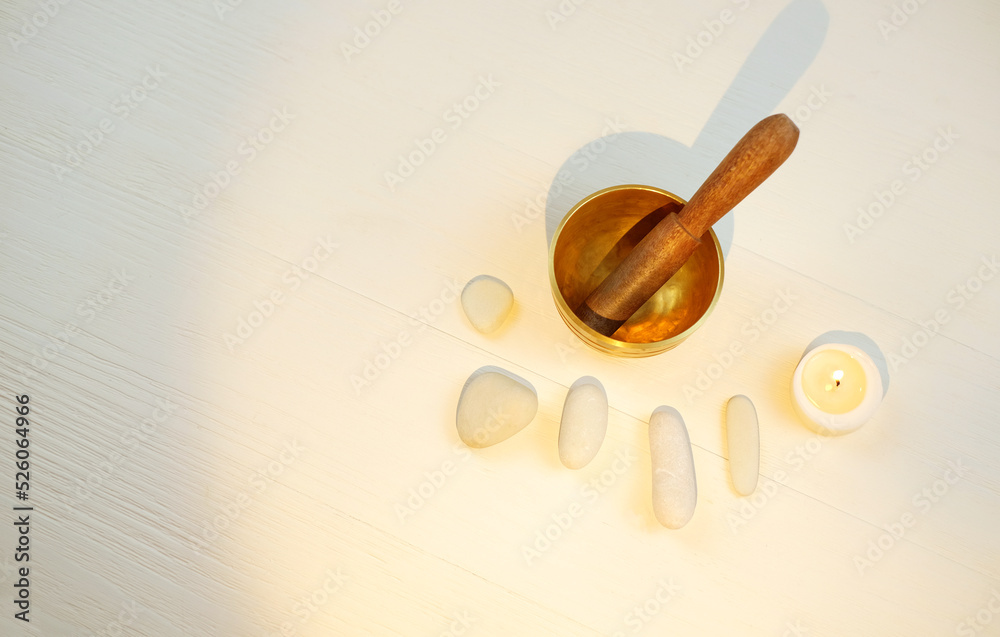 Tibetian singing bowl, candle and stones on white wooden background for sound therapy, with copy space, top view Tibetian singing bowl, candle and stones on white wooden background for sound therapy, with copy space, top view