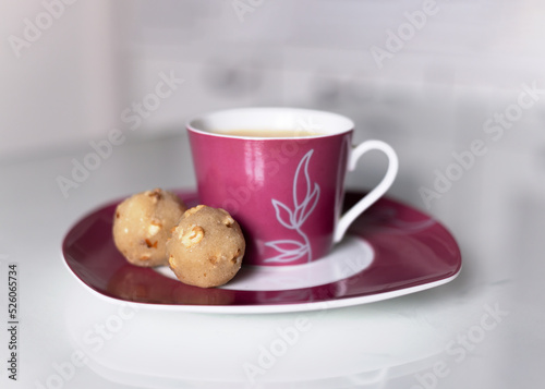 Marzipan made from almond flour and sweetener. A healthy low-carb and high-fat keto dessert. Alternative sweets and a mug of coffee on a white table. photo